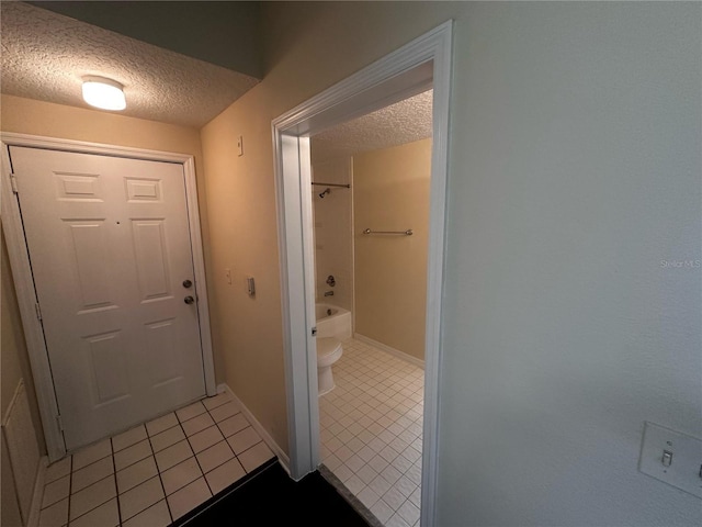 5560 Metrowest Blvd Unit 3-204, Orlando, FL 32811 - bathroom featuring a textured ceiling, tile patterned floors, toilet, and baseboards
