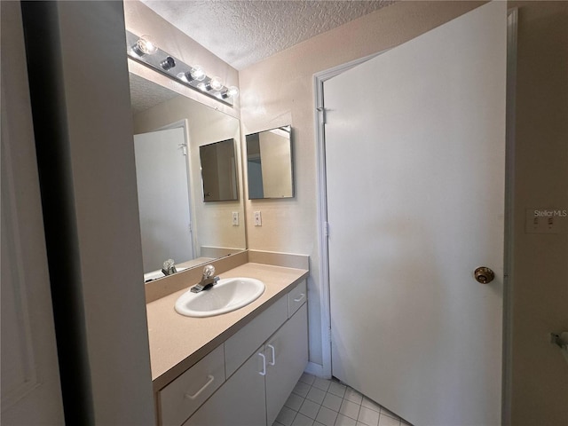 5560 Metrowest Blvd Unit 3-204, Orlando, FL 32811 - bathroom with a textured ceiling, tile patterned flooring, and vanity