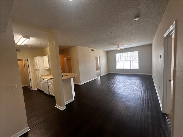 5560 Metrowest Blvd Unit 3-204, Orlando, FL 32811 - unfurnished living room with dark wood-style floors, a ceiling fan, a textured ceiling, and baseboards