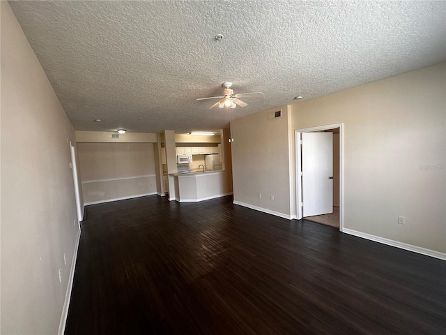 5560 Metrowest Blvd Unit 3-204, Orlando, FL 32811 - unfurnished living room featuring dark wood-style flooring, a ceiling fan, baseboards, and a textured ceiling