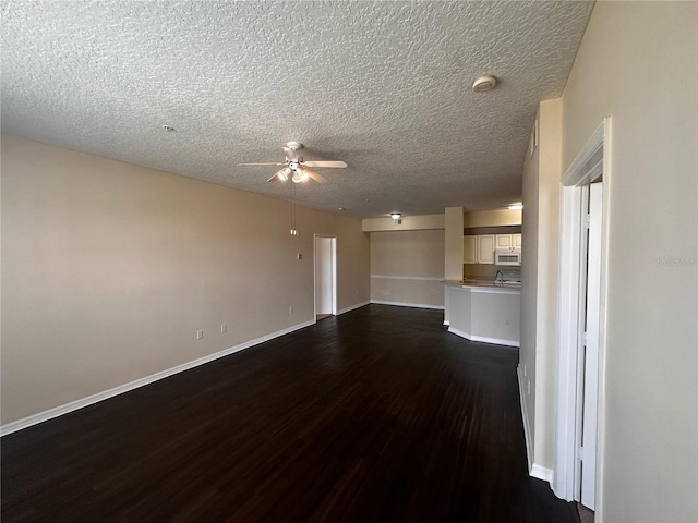5560 Metrowest Blvd Unit 3-204, Orlando, FL 32811 - unfurnished living room with dark wood-style flooring, ceiling fan, a textured ceiling, and baseboards