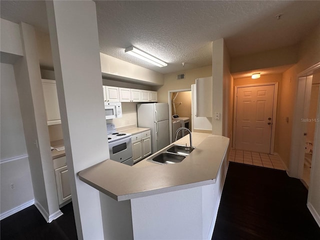 5560 Metrowest Blvd Unit 3-204, Orlando, FL 32811 - kitchen with white appliances, a sink, a textured ceiling, washer and dryer, and baseboards