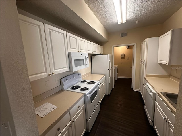 5560 Metrowest Blvd Unit 3-204, Orlando, FL 32811 - kitchen with white appliances, independent washer and dryer, a textured ceiling, white cabinets, and light countertops