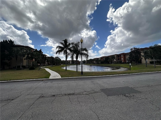 5560 Metrowest Blvd Unit 3-204, Orlando, FL 32811 - view of asphalt road featuring a water view, curbs, and street lights