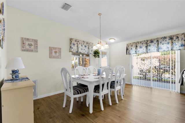 2111 Thornton Ter, The Villages, FL 32162 - dining space with wood finished floors, a chandelier, vaulted ceiling, and baseboards