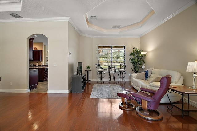 21206 Canoe Pass St, Clermont, FL 34715 - living room with arched walkways, hardwood / wood-style flooring, a raised ceiling, baseboards, and crown molding