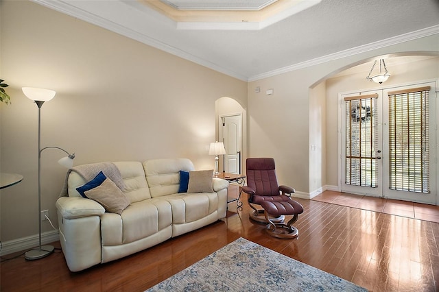 21206 Canoe Pass St, Clermont, FL 34715 - living room featuring arched walkways, wood finished floors, baseboards, ornamental molding, and french doors