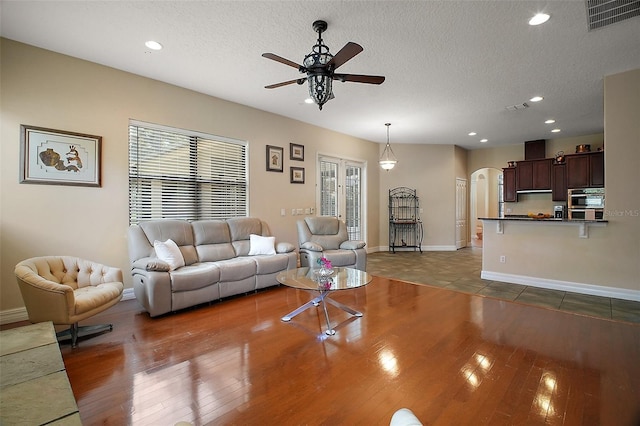21206 Canoe Pass St, Clermont, FL 34715 - living area with ceiling fan, arched walkways, a textured ceiling, wood finished floors, and recessed lighting