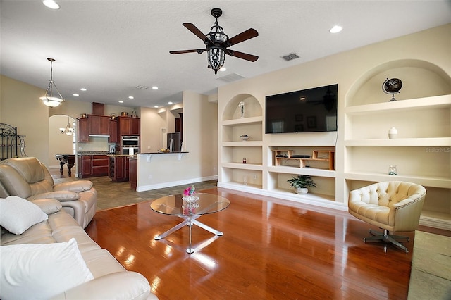 21206 Canoe Pass St, Clermont, FL 34715 - living area with built in features, baseboards, a ceiling fan, arched walkways, and recessed lighting