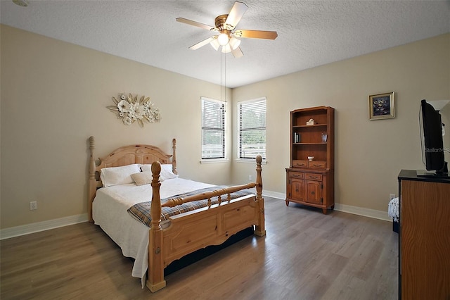 21206 Canoe Pass St, Clermont, FL 34715 - bedroom with light wood finished floors, a textured ceiling, baseboards, and ceiling fan