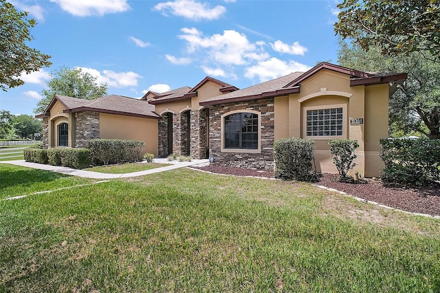 21206 Canoe Pass St, Clermont, FL 34715 - view of front of house with stucco siding, stone siding, and a front yard
