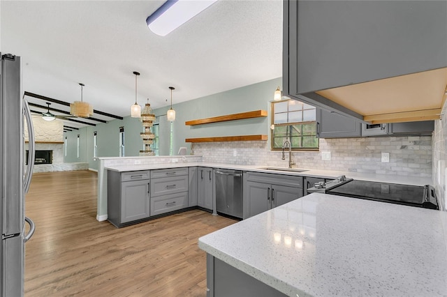 717 SE 46th Ct, Ocala, FL 34471 - kitchen with gray cabinets, appliances with stainless steel finishes, a peninsula, tasteful backsplash, and light wood finished floors