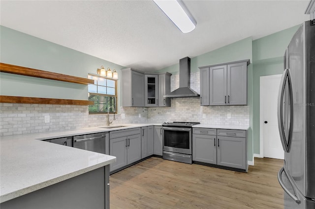 717 SE 46th Ct, Ocala, FL 34471 - kitchen featuring stainless steel appliances, gray cabinetry, wall chimney exhaust hood, open shelves, and tasteful backsplash