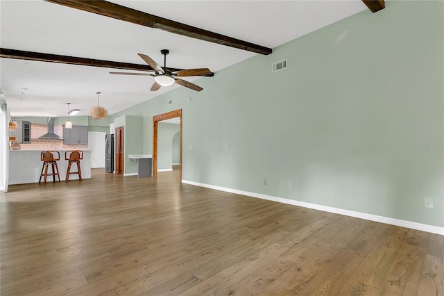 717 SE 46th Ct, Ocala, FL 34471 - unfurnished living room featuring beamed ceiling, a ceiling fan, and wood finished floors