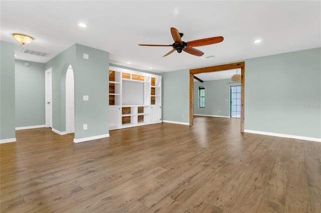 717 SE 46th Ct, Ocala, FL 34471 - unfurnished living room featuring ceiling fan, arched walkways, wood finished floors, and recessed lighting