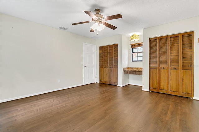 717 SE 46th Ct, Ocala, FL 34471 - unfurnished bedroom featuring multiple closets, dark wood-style flooring, and ceiling fan