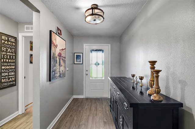 12952 Del Lago Dr, Astatula, FL 34705 - entryway with wood finished floors, baseboards, and a textured ceiling