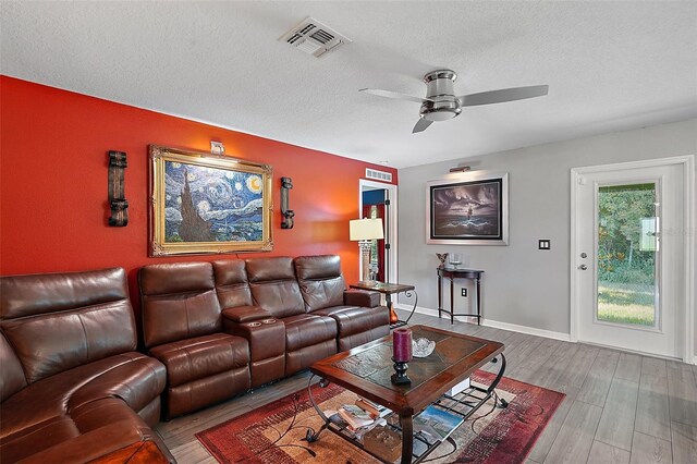 12952 Del Lago Dr, Astatula, FL 34705 - living area featuring a ceiling fan, wood finished floors, a textured ceiling, and baseboards