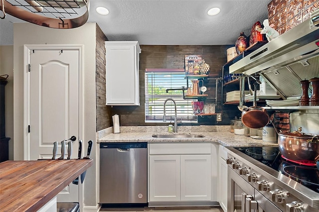 12952 Del Lago Dr, Astatula, FL 34705 - kitchen featuring stainless steel dishwasher, a sink, wood counters, a textured ceiling, and stove