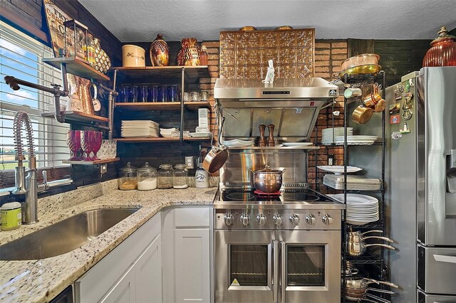 12952 Del Lago Dr, Astatula, FL 34705 - kitchen featuring appliances with stainless steel finishes, open shelves, a sink, extractor fan, and a textured ceiling