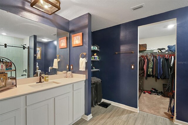 12952 Del Lago Dr, Astatula, FL 34705 - full bath with vanity, wood finished floors, a spacious closet, baseboards, and a tile shower