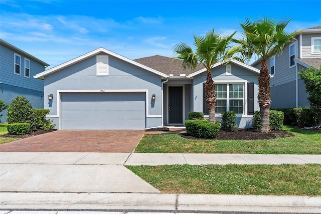 17112 Goldcrest Loop, Clermont, FL 34714 - ranch-style house featuring stucco siding, decorative driveway, and a garage