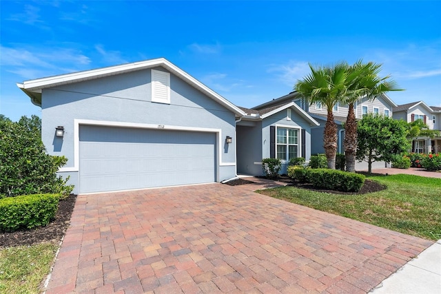 17112 Goldcrest Loop, Clermont, FL 34714 - single story home featuring stucco siding, decorative driveway, and a garage