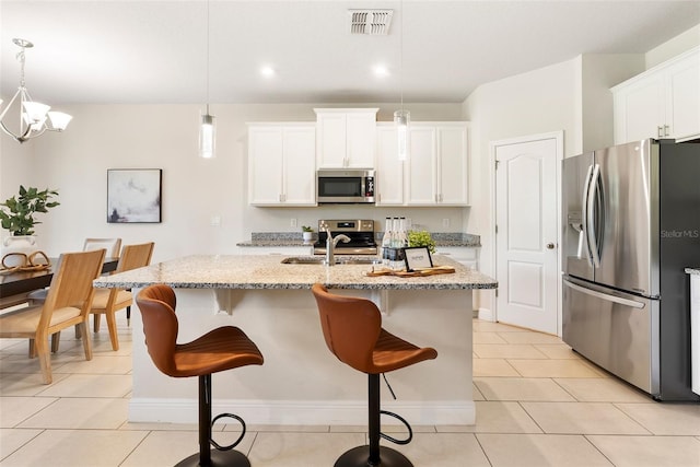 17112 Goldcrest Loop, Clermont, FL 34714 - kitchen featuring stainless steel appliances, light tile patterned flooring, an island with sink, white cabinetry, and recessed lighting