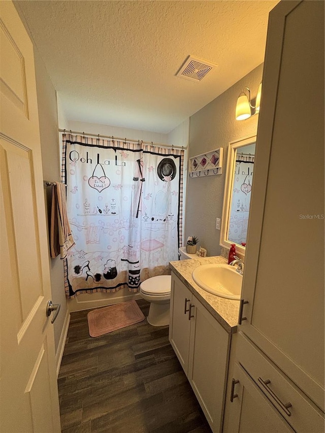 5547 SE 91st Pl, Ocala, FL 34480 - bathroom featuring wood finished floors, toilet, vanity, a textured ceiling, and shower / bathtub combination with curtain