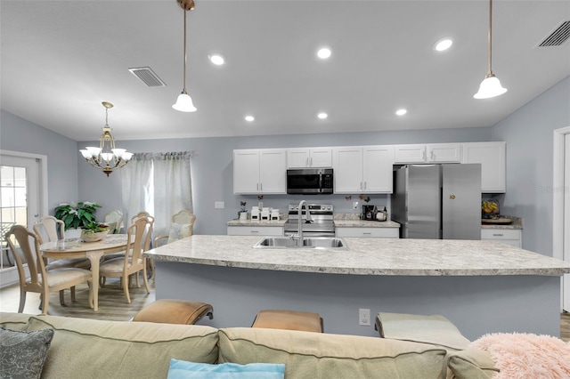 5547 SE 91st Pl, Ocala, FL 34480 - kitchen with stainless steel appliances, a chandelier, white cabinets, light countertops, and recessed lighting