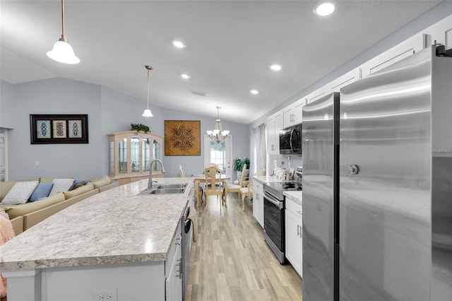 5547 SE 91st Pl, Ocala, FL 34480 - kitchen featuring stainless steel appliances, vaulted ceiling, light wood-style floors, white cabinets, and a kitchen island with sink
