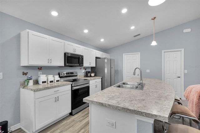 5547 SE 91st Pl, Ocala, FL 34480 - kitchen with stainless steel appliances, light wood-style flooring, lofted ceiling, a breakfast bar, and white cabinets