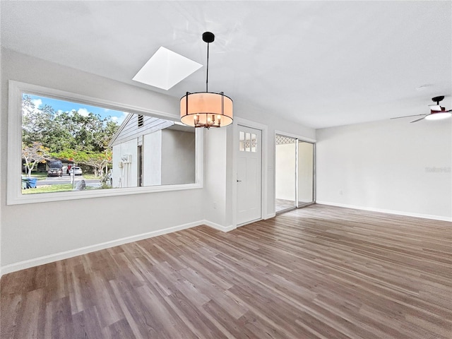 5136 Cedar Hammock Dr, Sarasota, FL 34232 - spare room featuring a chandelier, wood finished floors, baseboards, and a skylight