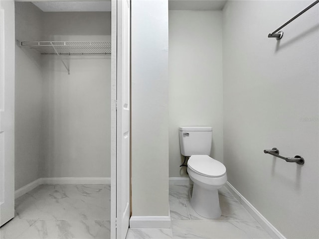 5136 Cedar Hammock Dr, Sarasota, FL 34232 - bathroom with marble look tile flooring, toilet, baseboards, and a spacious closet