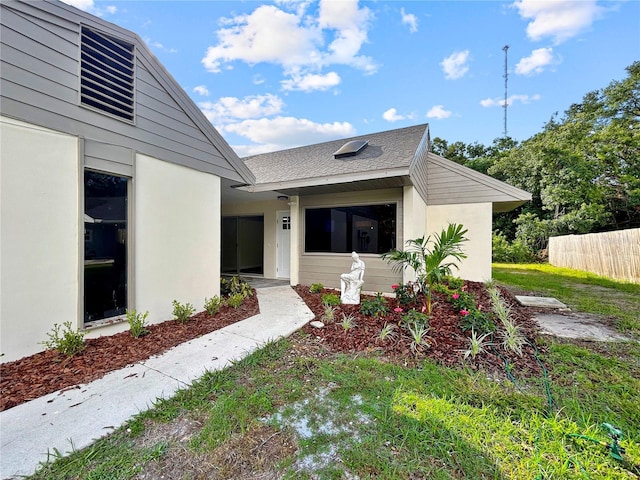 5136 Cedar Hammock Dr, Sarasota, FL 34232 - view of exterior entry with stucco siding and a shingled roof