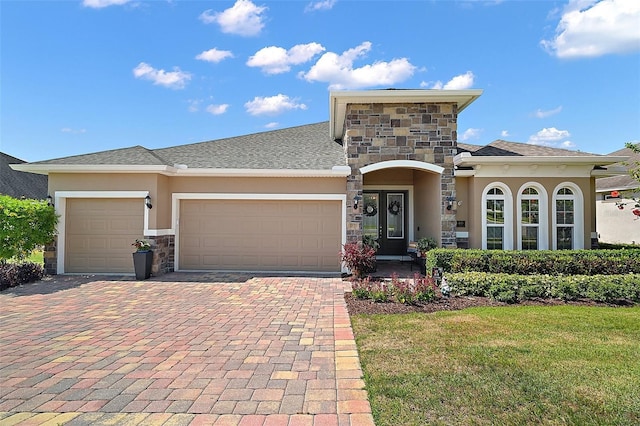 440 Bellissimo Pl, Howey In The Hills, FL 34737 - view of front of property with stone siding, stucco siding, decorative driveway, a garage, and a front yard