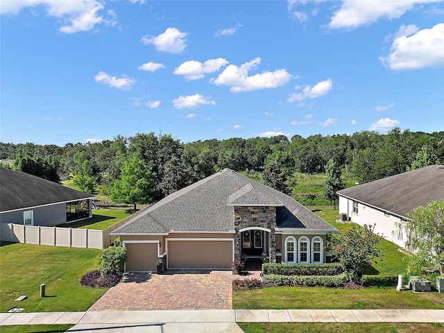 440 Bellissimo Pl, Howey In The Hills, FL 34737 - french country inspired facade with decorative driveway, a garage, and stone siding