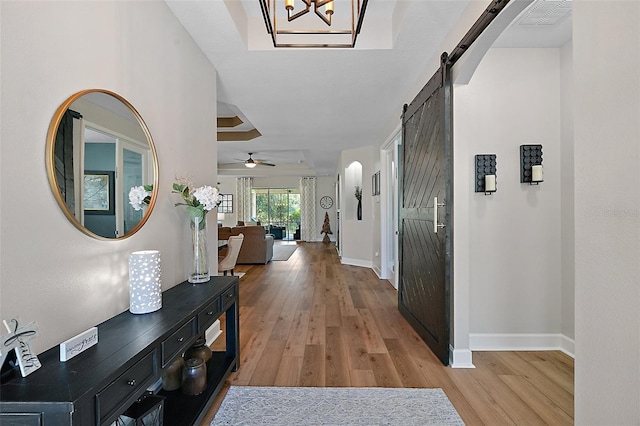 440 Bellissimo Pl, Howey In The Hills, FL 34737 - entrance foyer with a barn door, light wood finished floors, baseboards, and a ceiling fan