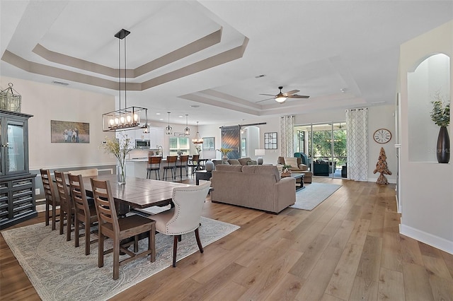 440 Bellissimo Pl, Howey In The Hills, FL 34737 - dining space featuring a raised ceiling, ceiling fan, light wood-type flooring, and baseboards