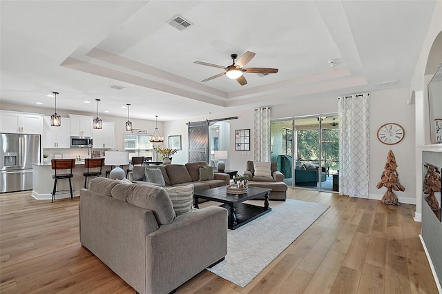 440 Bellissimo Pl, Howey In The Hills, FL 34737 - living area featuring a raised ceiling, a ceiling fan, a barn door, plenty of natural light, and recessed lighting