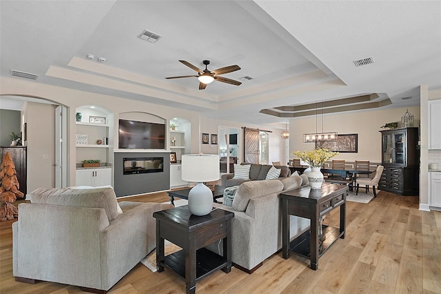 440 Bellissimo Pl, Howey In The Hills, FL 34737 - living area with a tray ceiling, ceiling fan, and light wood finished floors