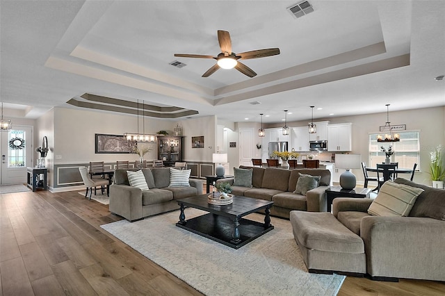 440 Bellissimo Pl, Howey In The Hills, FL 34737 - living area with a raised ceiling, a chandelier, ceiling fan, dark wood-style floors, and recessed lighting