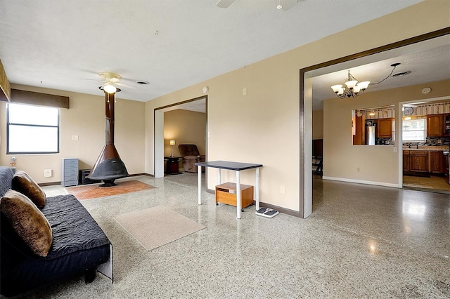 2007 Mosher Dr, Orlando, FL 32810 - living room with ceiling fan, baseboards, a wood stove, and speckled floor