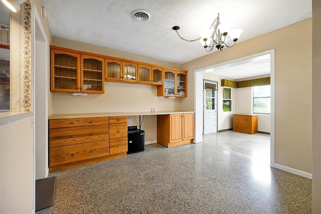 2007 Mosher Dr, Orlando, FL 32810 - kitchen with baseboards, a chandelier, glass insert cabinets, brown cabinets, and a textured ceiling