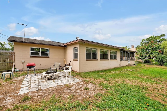 2007 Mosher Dr, Orlando, FL 32810 - rear view of house with an outdoor fire pit, a sunroom, and concrete block siding