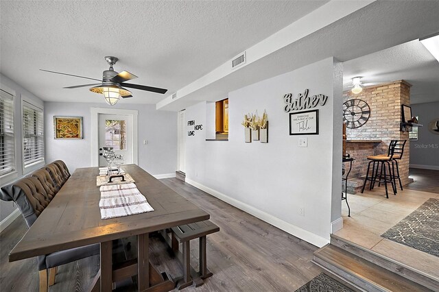 10303 SE Sunset Harbor Rd, Summerfield, FL 34491 - dining space with a ceiling fan, a textured ceiling, baseboards, and wood finished floors