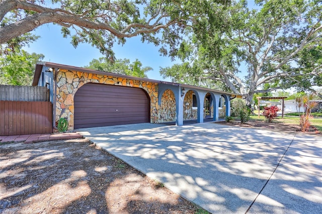 6443 34th Ave N, Saint Petersburg, FL 33710 - view of front facade featuring stone siding, concrete driveway, and an attached garage