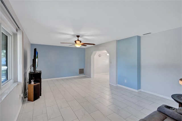 6443 34th Ave N, Saint Petersburg, FL 33710 - unfurnished living room with arched walkways, ceiling fan, and baseboards