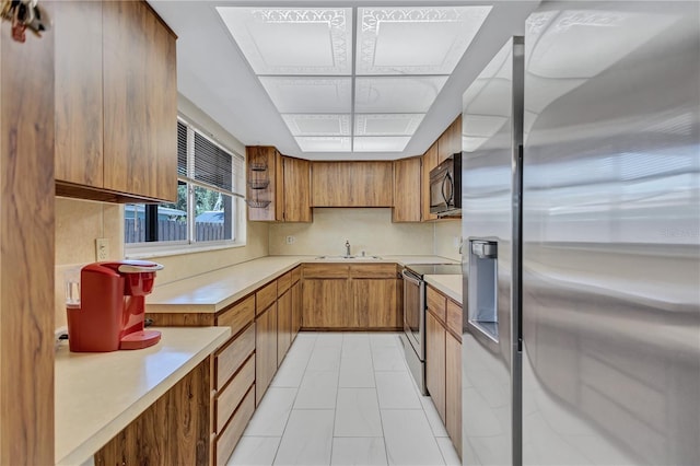 6443 34th Ave N, Saint Petersburg, FL 33710 - kitchen with appliances with stainless steel finishes, brown cabinets, light countertops, and a sink