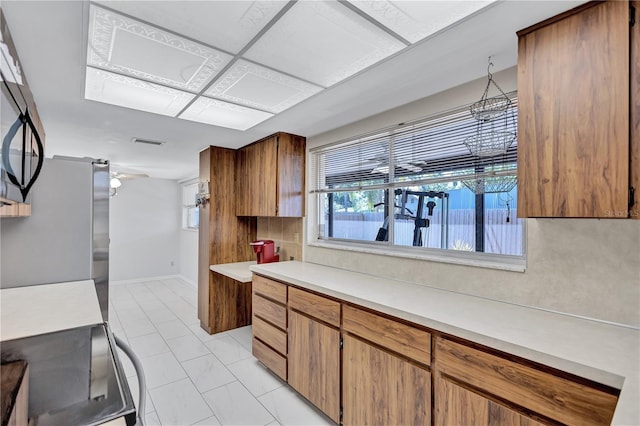 6443 34th Ave N, Saint Petersburg, FL 33710 - kitchen featuring freestanding refrigerator, light countertops, electric stove, and brown cabinetry